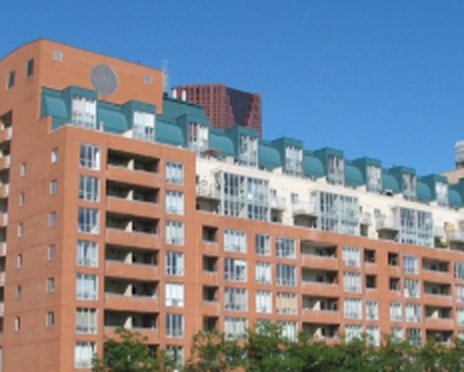 Brick co-operative apartment building with balconies under a blue sky