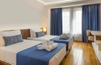 Clean hotel room with two made beds and folded towels